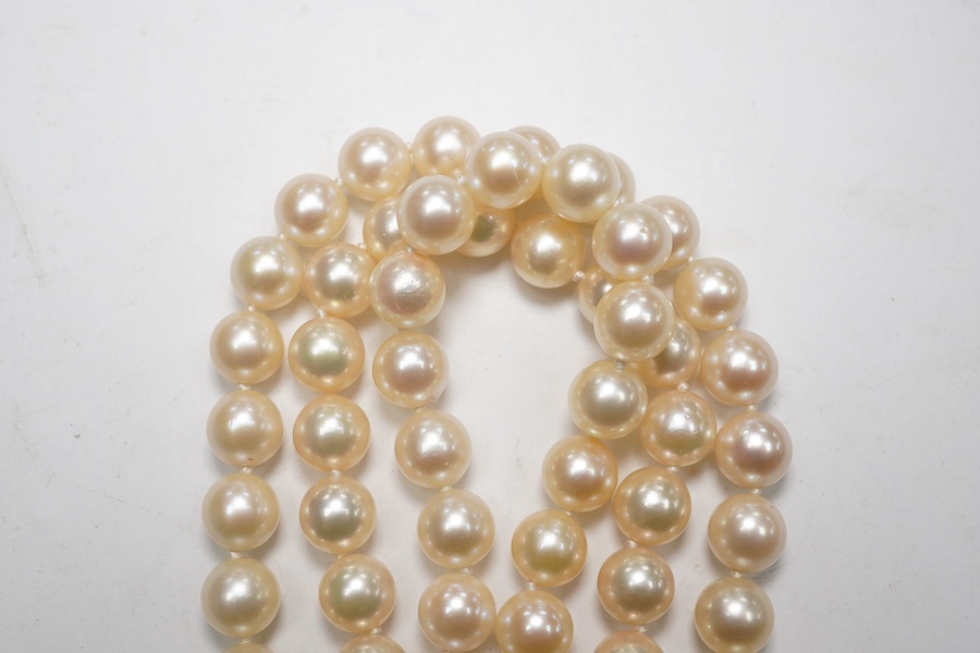 A modern triple strand culture pearl necklace, with emerald cluster set 14k clasp, 48cm. Condition - poor to fair